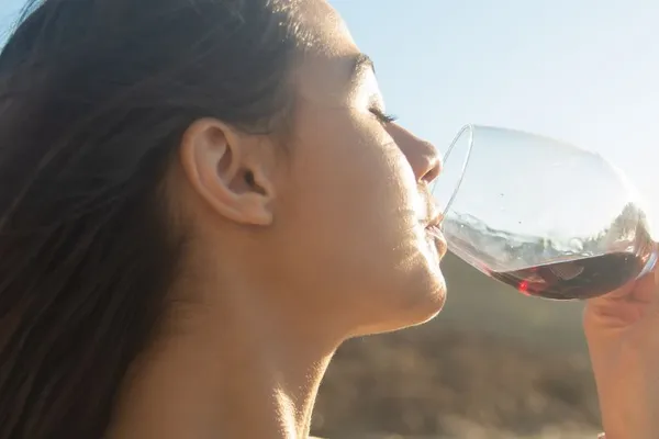 zijaanzicht van een vrouwe met een glas wijn
