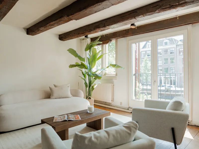 Lichte woonkamer met houten balken en uitzicht op de stad