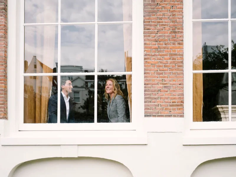 Nick Moser en Raymonde de Blaey in gesprek bij raam van grachtenpand