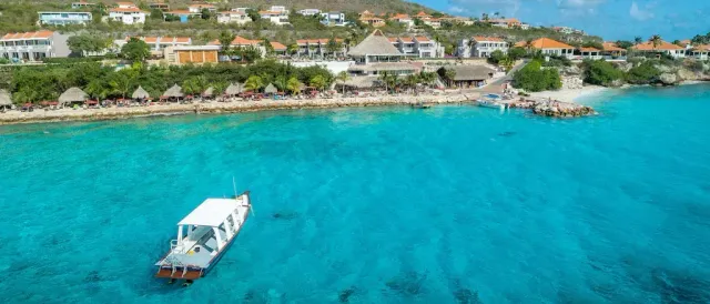 een blauwe zee met een boot op curacao coral estate
