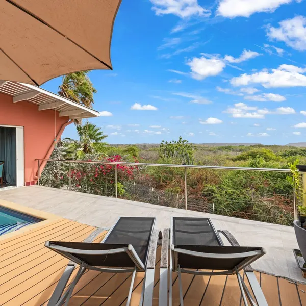 Wooden terrace with loungers overlooking greenery — Kaya Dornfelder  14, Curaçao.
