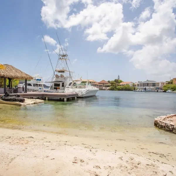 Small sandy beach with jetty and boats — Jan Sofat 193, Curaçao.