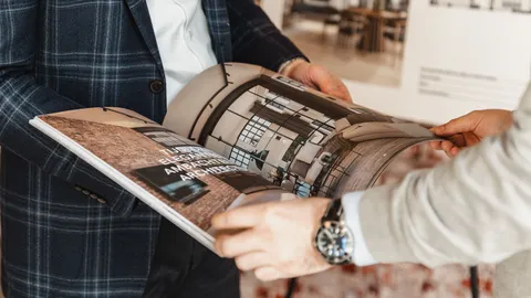 Klant bladert door een woningbrochure met foto's van het interieur