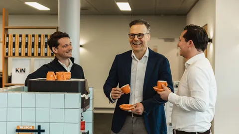 Collega's drinken lachend koffie samen in de kantine
