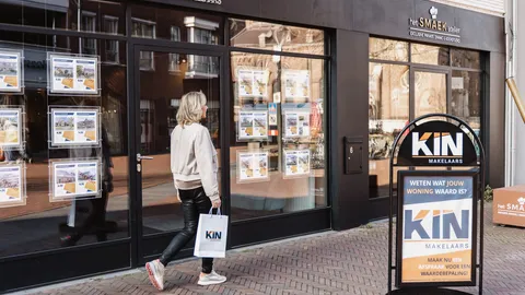 Voorbijganger met KIN-tas voor de etalage van het kantoor